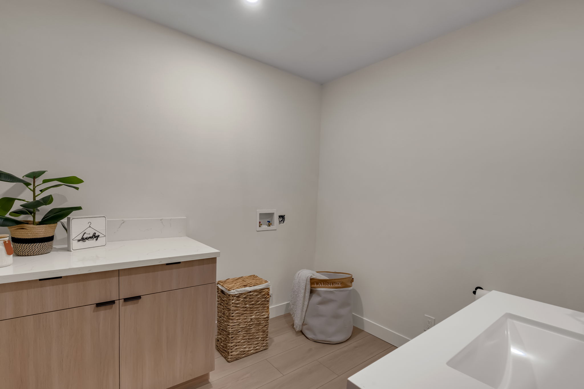 Laundry room with quartz counter and cabinetry